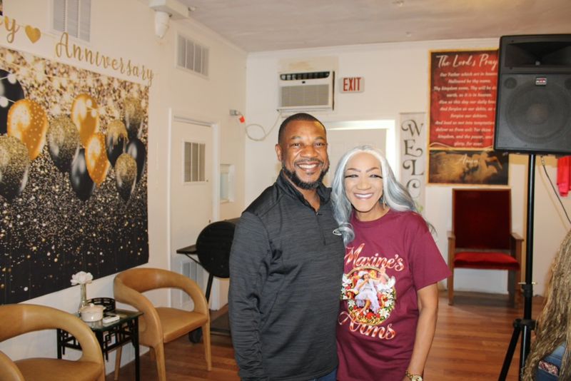 Founder Dr. Pamela L. McFadden-Singleton smiling beside a guest in front of a celebration backdrop.