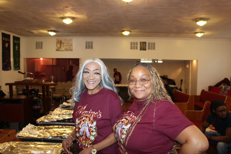 Two smiling Maxine’s Arms team members at the serving table.
